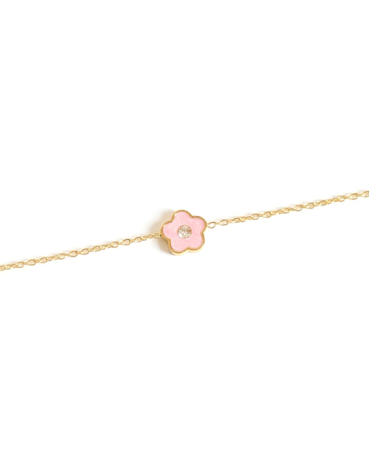Gold bracelet with a pink flower charm on a white background